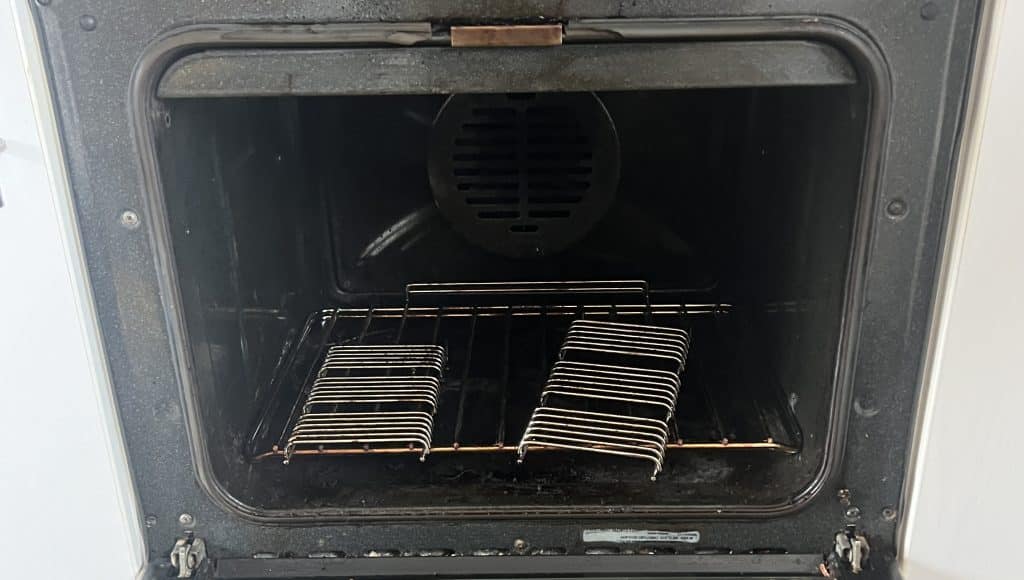 Greasy oven racks before removing heavy burnt-on residue