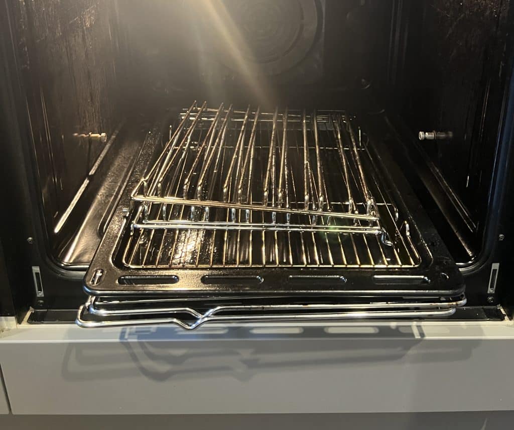 Clean stainless-steel oven racks and trays inside an oven