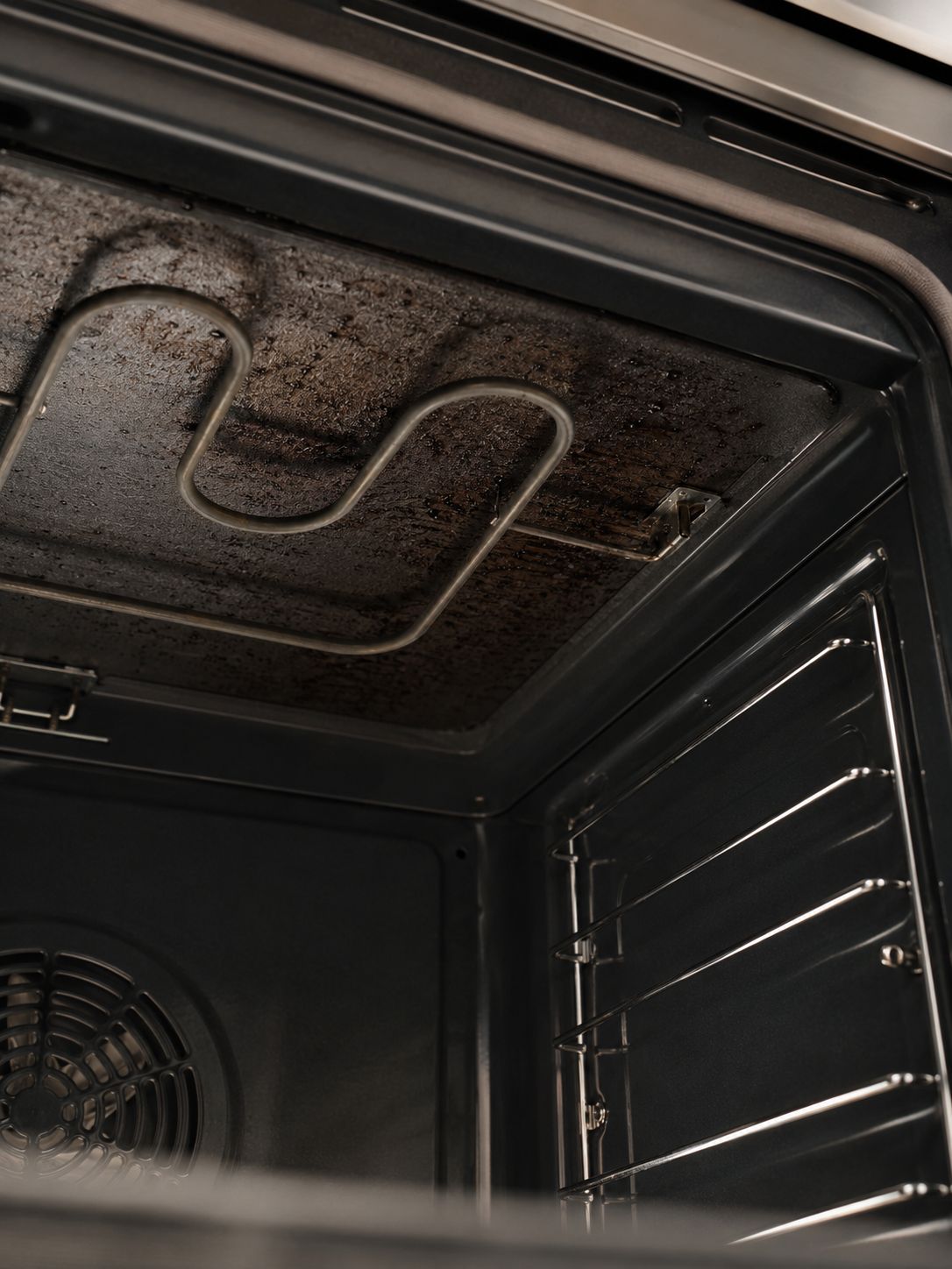Dirty oven roof above the upper grill heating element before cleaning