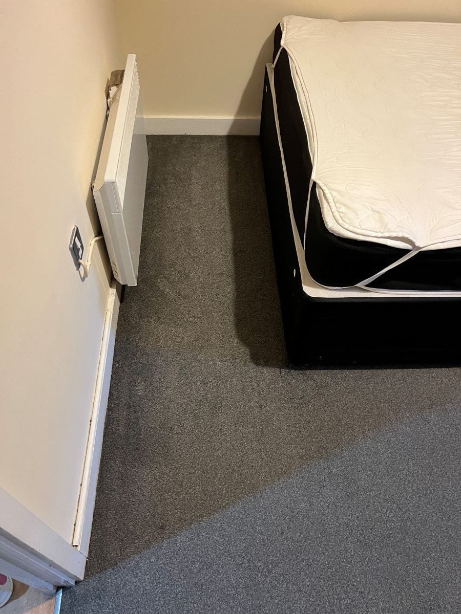 Grey bedroom carpet beside the bed after professional cleaning in Bearwood