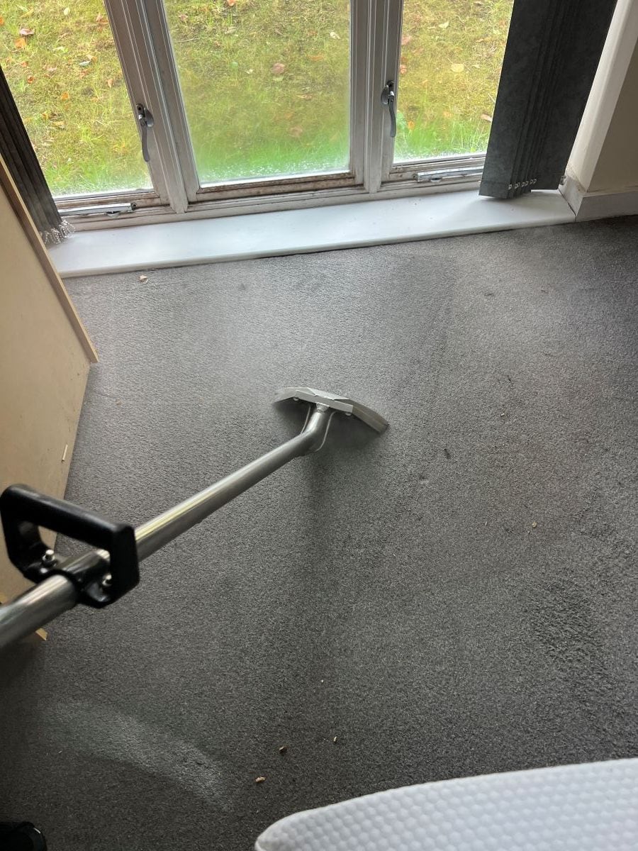 Carpet cleaning wand being used on a grey bedroom carpet in Bearwood
